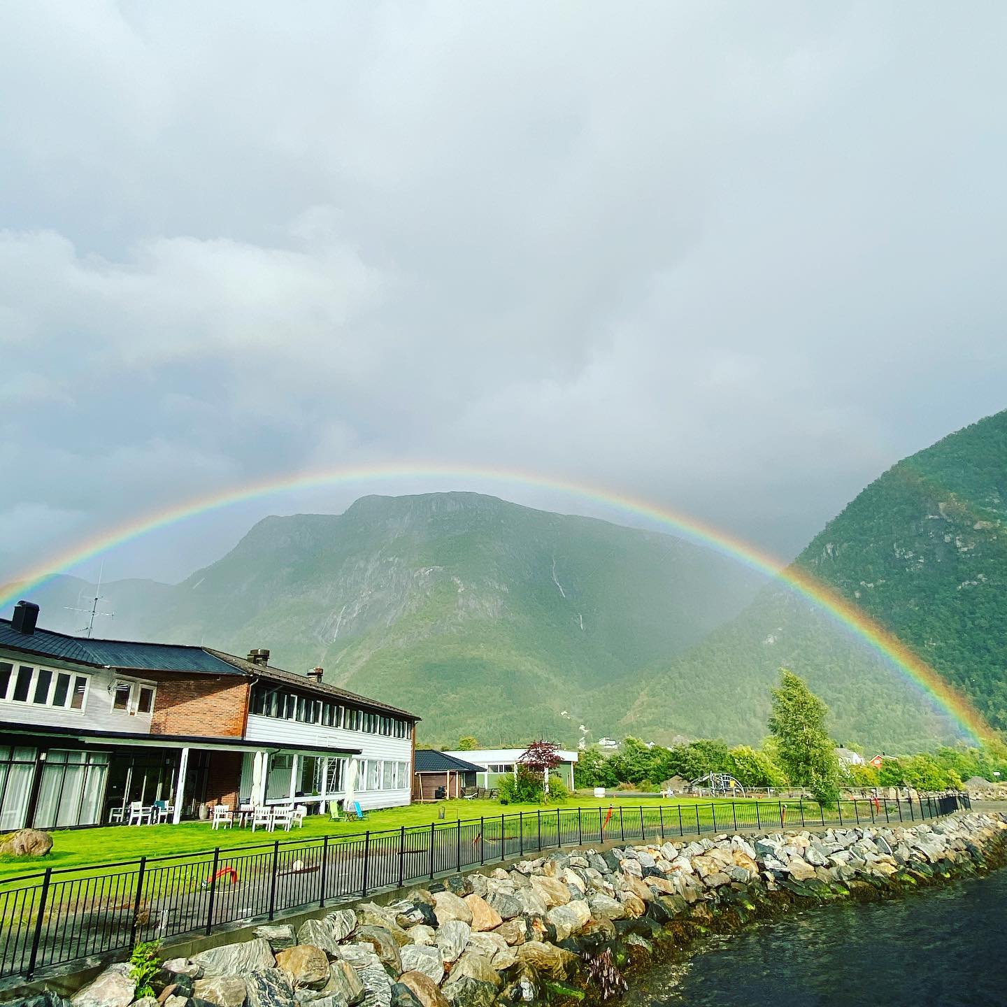 Rainbow over mountains and houses